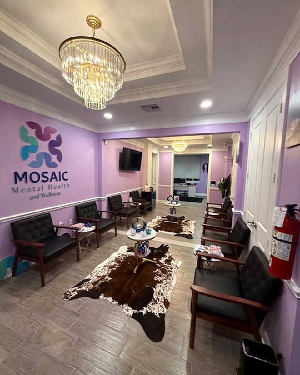 The Mosaic lobby in Katy, with the Mosaic logo wall and a chandelier